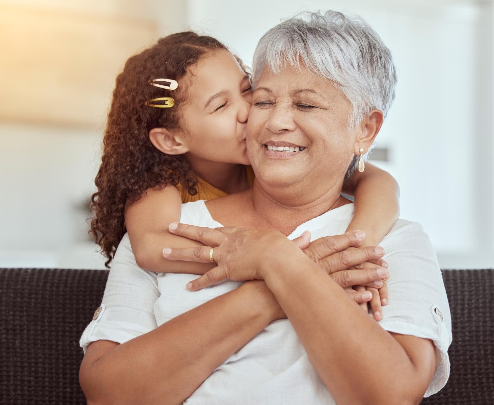 Abuela y nieta compartiendo un momento tierno en el sofá